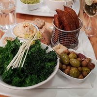 Mixed side dishes - hummous, wedges, olives and kale. at Manna London Restaurant - Maybe closed in North West London