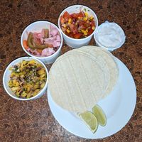 Mexican menu home delivery. Pineapple and jalepeno salsa, escabeche (Mexican pickles), toasted corn pico de galo, and vegan sour cream at Blue Moon Cafe in Sheffield