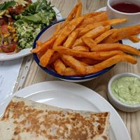 Iman bayildi and salad, bean burrito, sweet potato fries, garlic and parsley mayo, wild berry tea. at Blue Moon Cafe in Sheffield