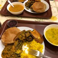 Dinner plate including soup, rice, two vegetable dishes, pokara, chutney, fry bread, and drink. at Govinda I in Budapest