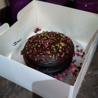 Fantastic vegan chocolate cake decorated with rose petals and pistacio nuts.  at VeGee Deli in Lowestoft