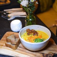 Malaysian Laksa Curry Soup - Warming, spicy, flavourful soup made using house-made laksa paste with anti-inflammatory fresh turmeric root, lemongrass, ginger & creamy coconut. A soupy stew of rice noodles, fragrant herbs, alfalfa sprouts & crunchy vegetables, topped with tempeh, fried shallots & lime at Matcha Cafe in Tibubeneng