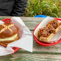 Pretzel burger with vegan cheese. Vegan dog with chili    at Golden Harvest Herban Farm and Bakery in Port Orford