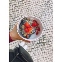 Charcoal vegan frozen yoghurt topped with some granola, fresh strawberries and shredded coconut. at Myiced Baixa in Lisbon