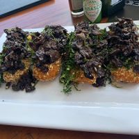 Polenta crostinis with mushrooms and crispy kale  at Mergulhao in Fernando De Noronha