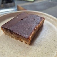 Caramel slice $7.50: delicious, lovely crunchy texture of biscuit, caramel, and chocolate, although noticeable coconut taste at Shift Eatery in Surry Hills