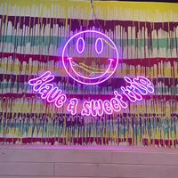 Neon sign on the colorful wall at Freedom Cakes Bakery in Madrid