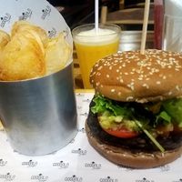 Black bean burger with guacamole, tomato, onions and greens, fresh homemade potato chips and an orange/passionfruit juice. Yum!! at Goodala Burger in Natal