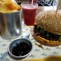 Soy burger, vegan cheddar, coconut "bacon", greens, tomato and carmelized onions, fresh chips, guava bbq sauce and a strawberry mint juice!!  at Goodala Burger in Natal