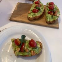 Avocado toast with tomatoes, pesto and peanuts.  at Ribeira d'Ilhas Beach in Ericeira