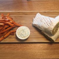 Vegan guacamole wrap with sweet fries on a bamboo board at D-Werk in Innsbruck