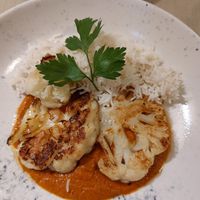 Cauliflower steak, curry sauce. at Gaudi&Naan in Ljubljana