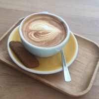 Oat milk flat white (and free lotus biscuit!) at Take Five Espressobar in Ghent