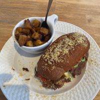 The pambazo, a Mexico City-style wet sandwich comprised of a hoagie bun dipped in hot sauce, walnut chorizo, potatoes, queso, salsa, avocado, remoulade, and parmesan at Two Dollar Radio Headquarters in Columbus