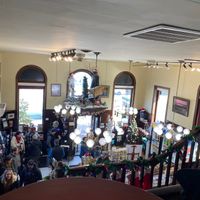 Crowded downstairs covered in Christmas decorations, taken from upstairs  at The Met Coffee House and Art Gallery in North Conway