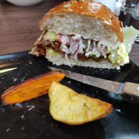 The Wulf Burger [£14.95] - Seitan patty, tomato, baby gem, pickle, red onion, cashew aioli in a brioche bun with sauerkraut, sweet potato and potato wedges.  at Wulf & Lamb Chelsea in London