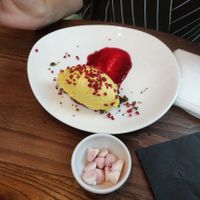 Mango & Passionfruit Cheesecake [£ 6.95] - Served on a base of macadamia, pistachios and sesame seeds topped with raspberry crumble at Wulf & Lamb Chelsea in London