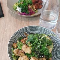 Green bowl in the front, cauliflower fritters in the back at SoulPod Foods in Croydon