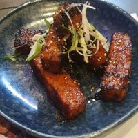 sticky vegan ‘ribs’: Mushroom + soya protein 'ribs' glazed with a sweet + spicy sticky sauce topped with sesame seeds + spring onion at Wagamama - Trafford Centre in Manchester