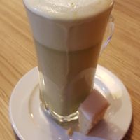 Matcha latte with a piece of lemon cake at be Well in Bochum