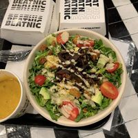 Caesar salad. On the left is the cheese sauce for dipping fries in. My friend also got loaded mushroom fries (box) at Beatnic - Rockefeller Plaza in New York City
