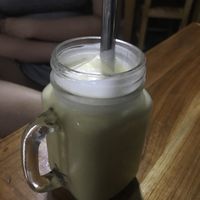 Mango smoothie made with coconut milk featuring a fat metal straw  at Phonheuang Cafe in Luang Prabang