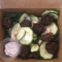 Mixed raw salad with spinach, courgette, cashews and raw falafels, and vegan mayo at Missfagiola in Bologna