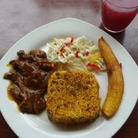 Example of daily almuerzo - second course: strawberry juice and rice with lentils, seitan with sauce, plantain, and small salad at Carmita's Pancake House Restaurant in Montanita