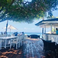 Outdoor seating by the beach  at Cotton House Beach Cafe in Mustique