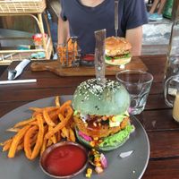 Tempeh burger with avocado salsa, hummus and sweet potato Fries for 70k++ ! Sooo good. The vegetarian chickpea spinach burger in the back was not as nice and more expensive.  at Bukit Cafe in Pecatu