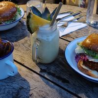 An evening meal: two fried chicken burgers, a pina colada, and some potato wedges. at Aujourd'hui Demain Cafe in Paris