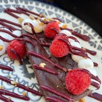 Brownie with red fruits and cream. at Bosque in Sintra