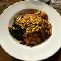 Tempeh bacon hash: Potatoes and caramelized onions, seasonal vegetables, tempeh bacon and kale, seasoned with herbs and smoked paprika. topped with green chile and tofu at City O' City in Denver