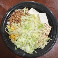 Slurp spicy before broth with tofu, cabbage, corn, and crispy onions  at Slurp Ramen in Port Jefferson