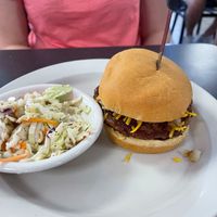 Vegan BBQ Burger with Beyond patty and a side of vegan cole slaw.  Burger topped with grilled onions, BBQ sauce, vegan cheeze, and vegan mayo at Ocala's Downtown Diner in Ocala