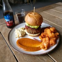 Vegan chorizo-style burger, home-smoked tomato ketchup, coleslaw, relish, paprika crisps, and a Karma Cola at W6 Garden Centre Cafe in West London