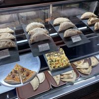 Empanadas, pizza slices and focaccia.  at Pastelería y Panadería Sinfonía in Santiago