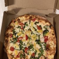Vegan cheese with tomatoes, spinach and pineapplee  at Pizzolis in Washington