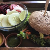 Seitan burger on whole grain bread with a salad.  at La Bruja Vegan Foods in Antigua
