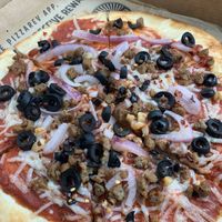 Daiya non-dairy cheese and Beyond sausage pizza with black olives and red onions. at PizzaRev in Shreveport