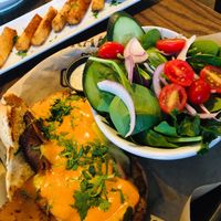 Vegan Philly, side salad with vegan ranch, yucca fries in background   at The Howe in Minneapolis