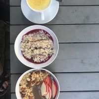 turmeric latte, overnight oats (plum preserves), and acai bowl with apples at My Goodness in Berlin