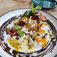 Loaded pancakes with Caramelised bananas, Fresh passion fruit and banana, Chocolate ganache, Mango coulis, Flaked almonds, Coconut cream at Nomad Café | Boutique in Weligama