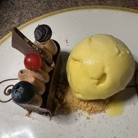 This is half the chocolate mousse cake. My husband had the other half and they pre divided it. Served here with mango gelato.   at Ike's Bistro in Oranjestad