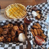 Top left corner going clockwise, cheesy bread. Chicken tenders mozzarella sticks ,cauliflower wings with vegan ranch at Chattanooga Pizza Co in Chattanooga
