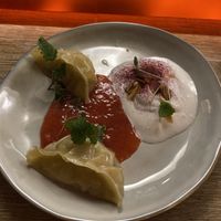 Pineapple gyoza dessert served with raspberry coulis and coconut and almond cream   at Marclee in Paris