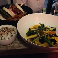 Left: 2 different vegan bao burgers with sweet potato fries; right: tom yum with tofu, vegetables and rice at Marclee in Paris