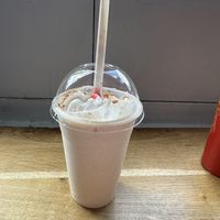 The large strawberry cheesecake milkshake with whipped cream; this was the highlight, it was so thick and creamy 🤤 I’d already started to drink it before taking this photo  at Temple of Seitan - Camden in North West London