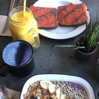 Blueberry muffin smoothie bowl with vanilla latte and strawberry and pineapple jam on toast with solar fusion smoothie  at Eight - The Health Lounge in Lisbon