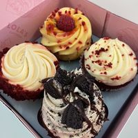 Top and the cupcake at the 9 o’clock position are vegan. Passionfruit and red velvet    at Lola's Cupcakes - Victoria Place in London